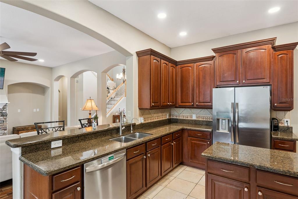 216 Juniper Ridge Court Sanford, FL 32771 - Photo 13 of 61 a kitchen with stainless steel appliances granite countertop a sink stove and refrigerator