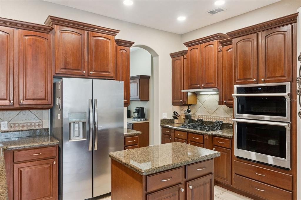 216 Juniper Ridge Court Sanford, FL 32771 - Photo 14 of 61 a kitchen with stainless steel appliances granite countertop a refrigerator stove and oven