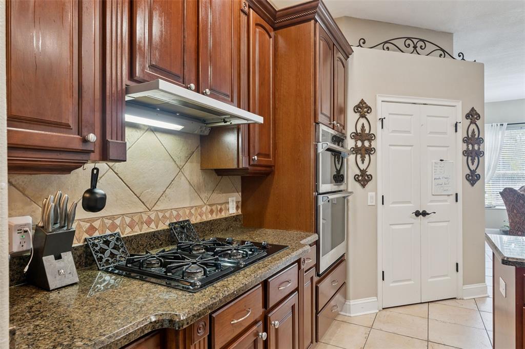 216 Juniper Ridge Court Sanford, FL 32771 - Photo 15 of 61 a kitchen with granite countertop a stove and a wooden cabinets