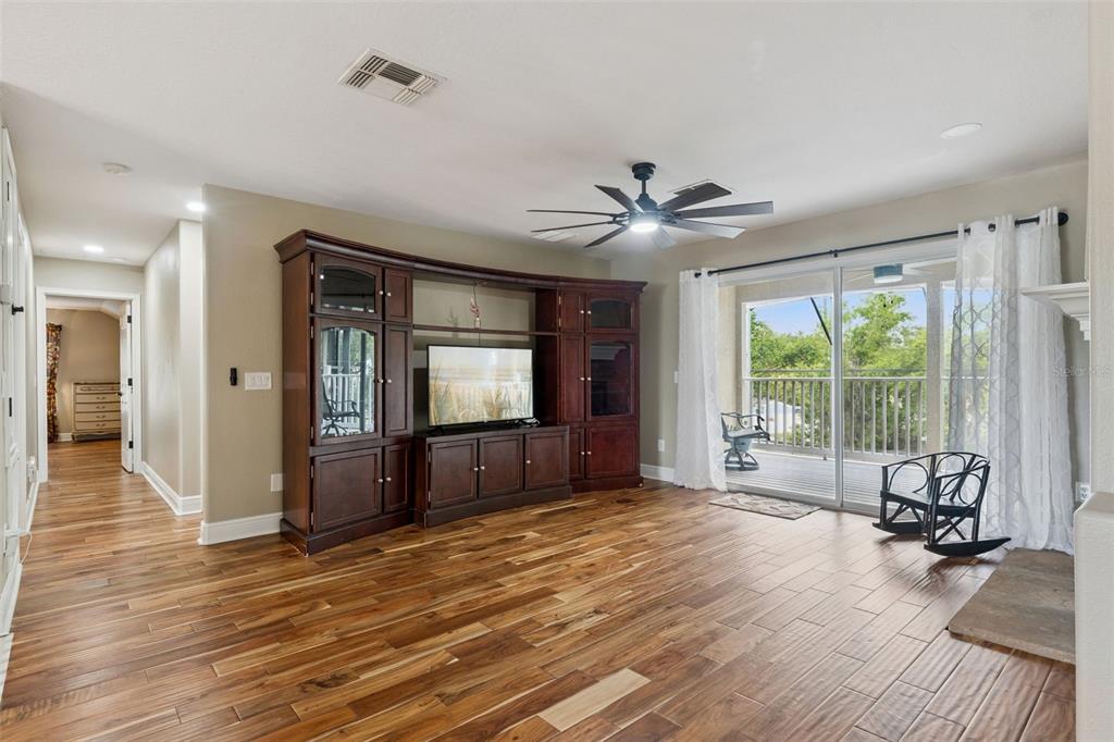 216 Juniper Ridge Court Sanford, FL 32771 - Photo 32 of 61 a living room with furniture tv and a floor to ceiling window