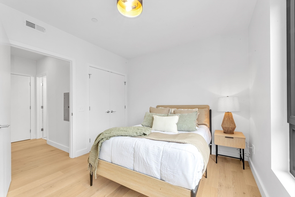 3992 Washington Street, Unit 302 Boston, MA 02131 - Photo 21 of 29 a bedroom with a bed and painting on the wall