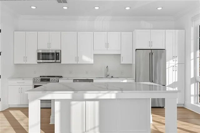 a kitchen with stainless steel appliances granite countertop a stove a sink and a refrigerator