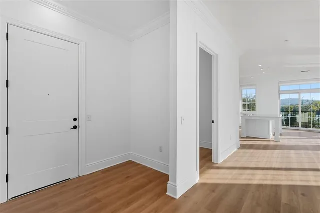 a view of a hallway with wooden floor and entryway