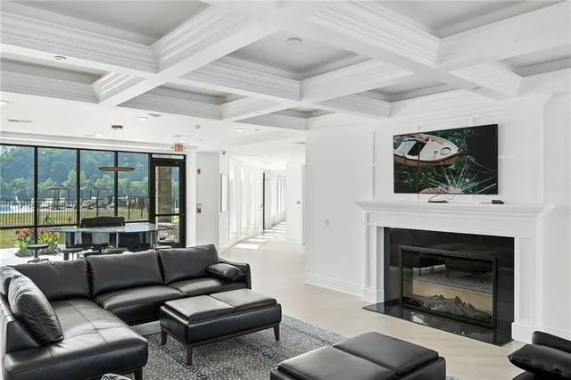 a living room with furniture wooden floor kitchen view and a chandelier
