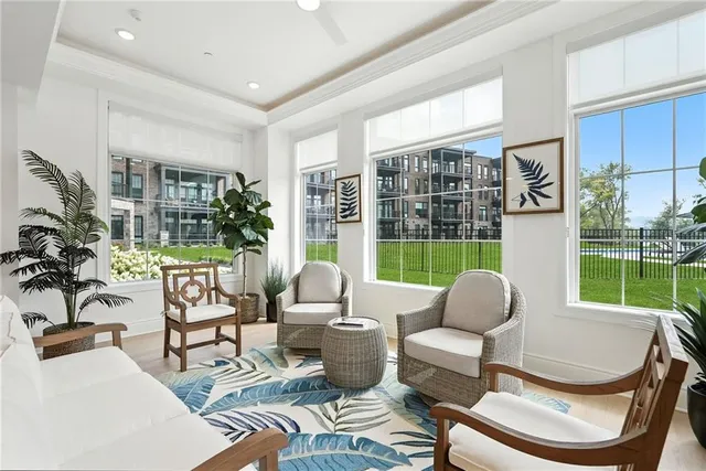 a living room with furniture kitchen and a large window