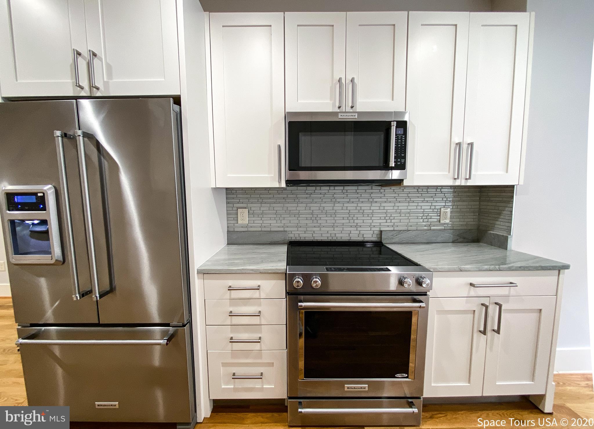 1505 9th Street Northwest, Unit A Washington, DC 20001 - Photo 9 of 10 a kitchen with stainless steel appliances granite countertop a refrigerator stove and microwave