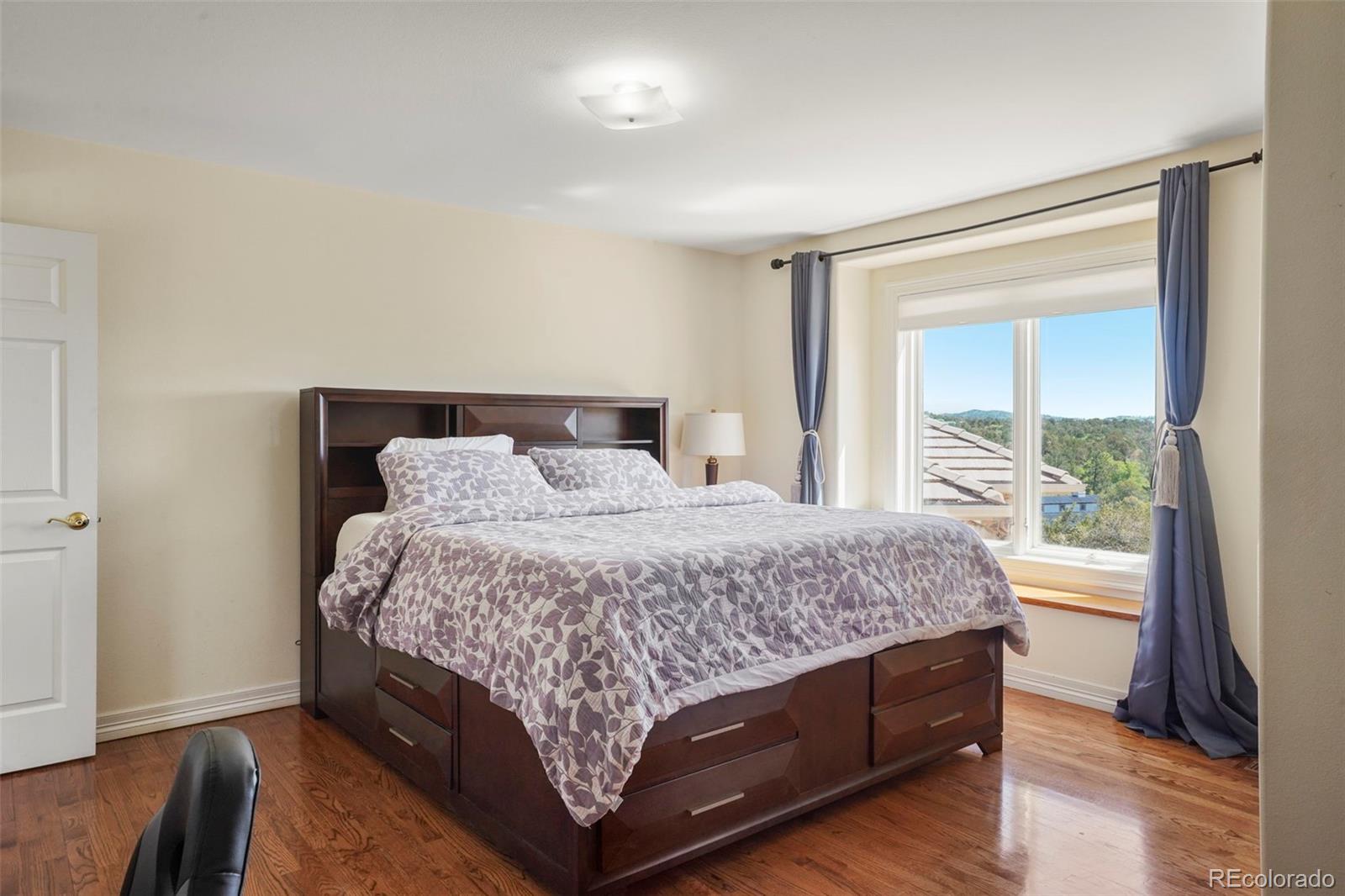 15010 Henry Ride Heights Colorado Springs, CO 80926 - Photo 16 of 50 a bedroom with a large bed and a large window
