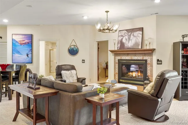 a living room with furniture a chandelier and a fireplace
