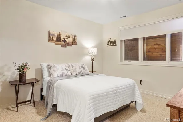 a bedroom with a bed and a painting on the wall