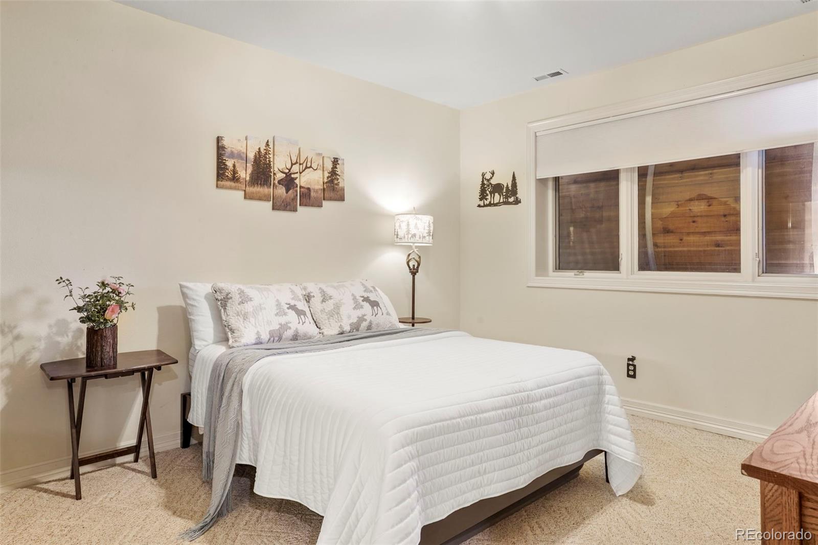 15010 Henry Ride Heights Colorado Springs, CO 80926 - Photo 26 of 50 a bedroom with a bed and a painting on the wall