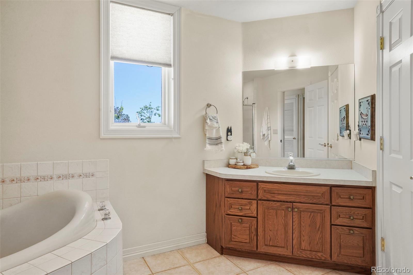 15010 Henry Ride Heights Colorado Springs, CO 80926 - Photo 28 of 50 a bathroom with a granite countertop sink mirror and bathtub