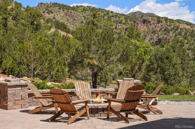 a view of a patio with table and chairs and floor to ceiling window