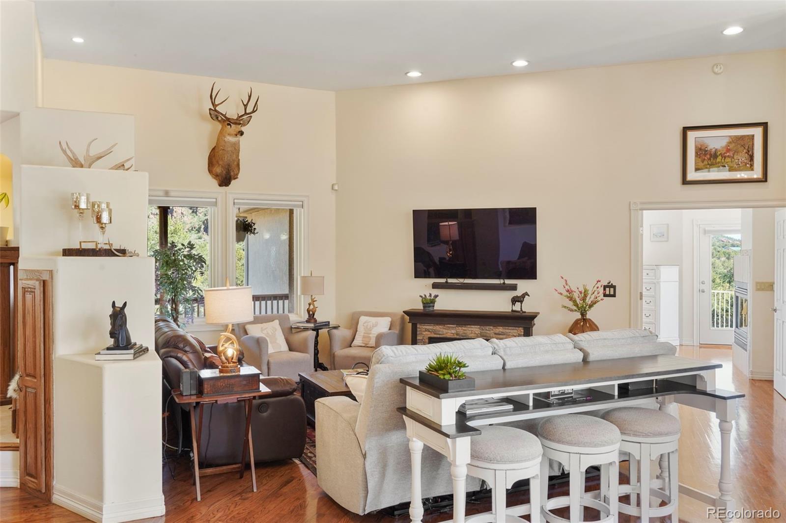 15010 Henry Ride Heights Colorado Springs, CO 80926 - Photo 4 of 50 a living room with furniture a flat screen tv and kitchen view