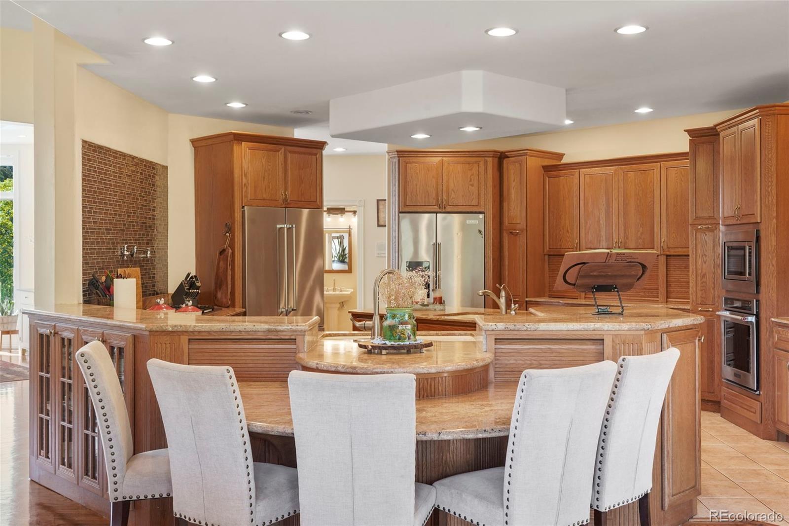 15010 Henry Ride Heights Colorado Springs, CO 80926 - Photo 6 of 50 a kitchen with stainless steel appliances kitchen island granite countertop a table and chairs