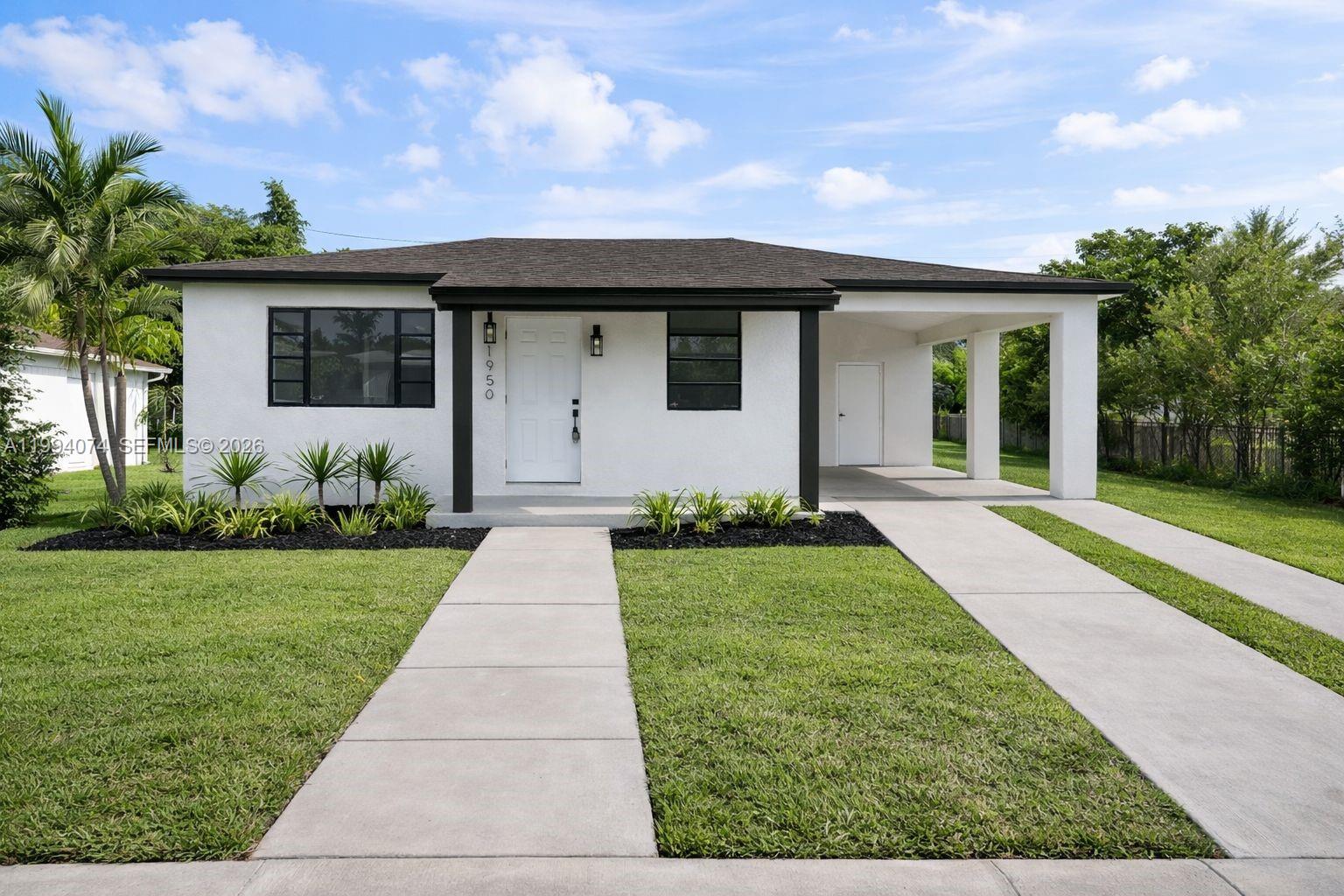 1950 Northwest 57th Street, Unit 1950 Miami, FL 33142 - Photo 2 of 10 a front view of a house with a yard and potted plants