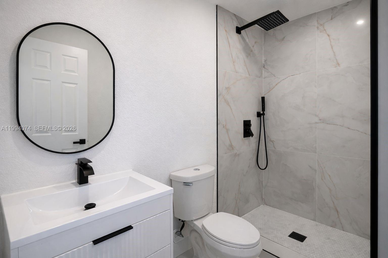 1950 Northwest 57th Street, Unit 1950 Miami, FL 33142 - Photo 9 of 10 a bathroom with a sink a toilet and a mirror