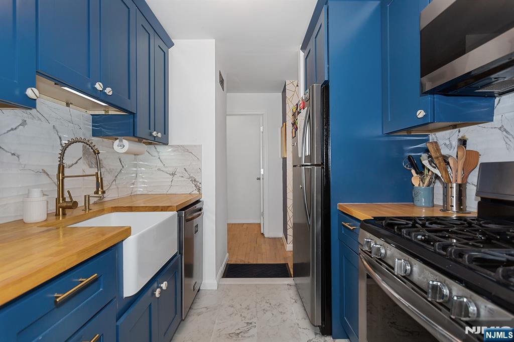25 River Road, Unit B11 Nutley, NJ 07110 - Photo 11 of 30 a kitchen with stainless steel appliances granite countertop a sink stove and refrigerator