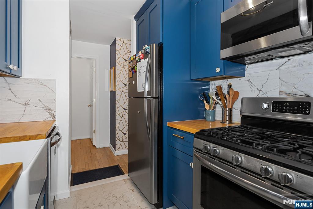 25 River Road, Unit B11 Nutley, NJ 07110 - Photo 12 of 30 a kitchen with stainless steel appliances granite countertop a stove and a refrigerator