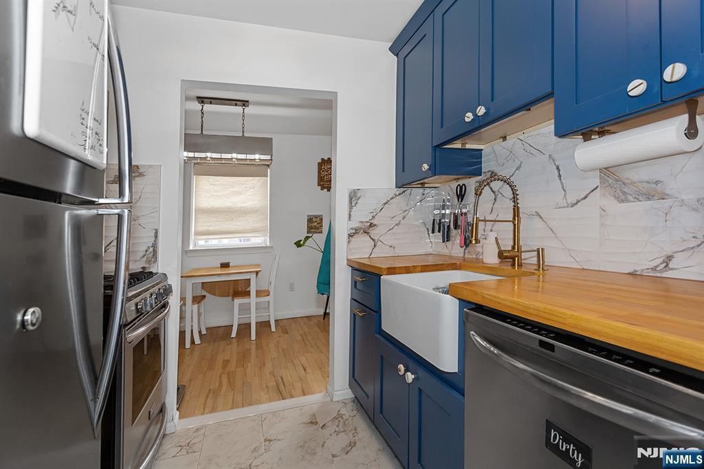 25 River Road, Unit B11 Nutley, NJ 07110 - Photo 13 of 30 a kitchen with stainless steel appliances granite countertop a sink stove and refrigerator