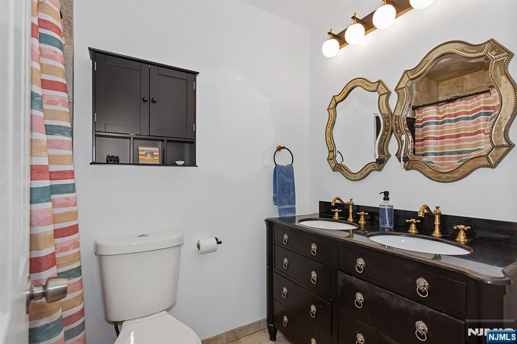 25 River Road, Unit B11 Nutley, NJ 07110 - Photo 17 of 30 a bathroom with a double vanity sink and a mirror