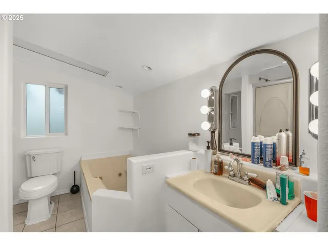 a bathroom with a sink a toilet and a mirror