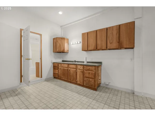 a kitchen with stainless steel appliances granite countertop a stove a sink and a refrigerator with wooden floor