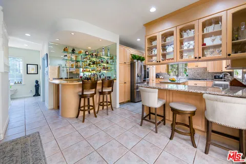 a kitchen with stainless steel appliances kitchen island granite countertop a refrigerator and a stove top oven