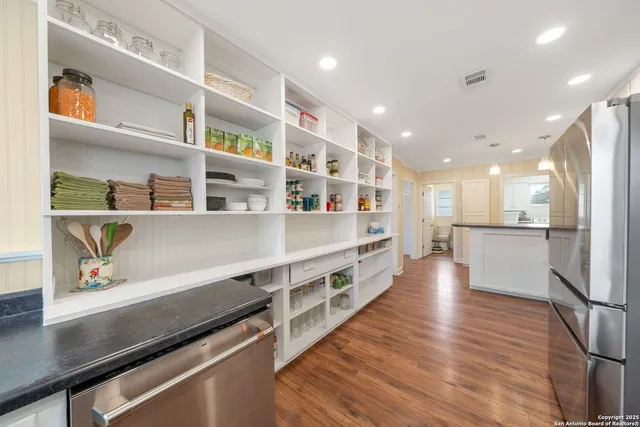 a view of kitchen with stainless steel appliances cabinets and wooden floor