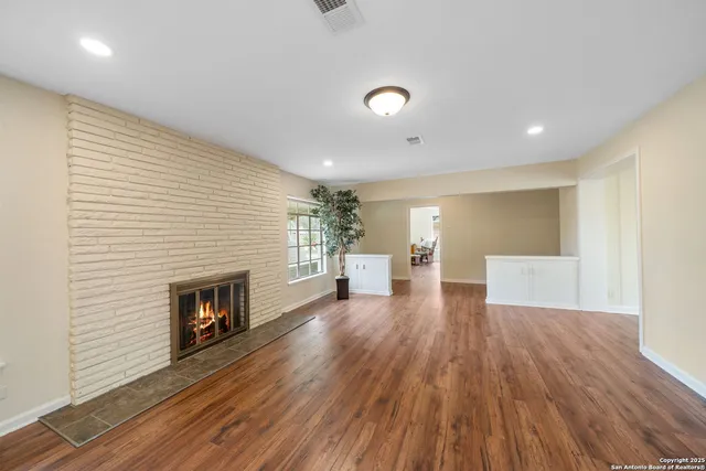 a view of a livingroom with wooden floor and a fireplace