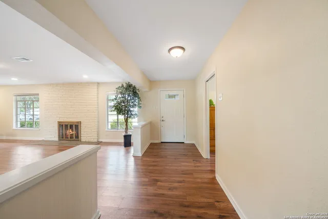 a view of a livingroom with wooden floor and a fireplace