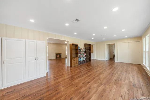 a view of an empty room with wooden floor