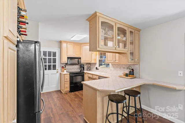 a kitchen with a refrigerator and a stove top oven