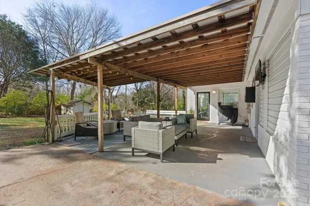 a view of a patio with a table and chairs and a barbeque