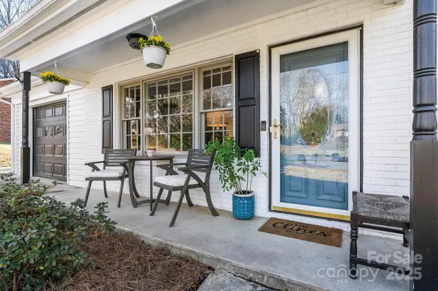 a view of a porch with chairs and potted plants