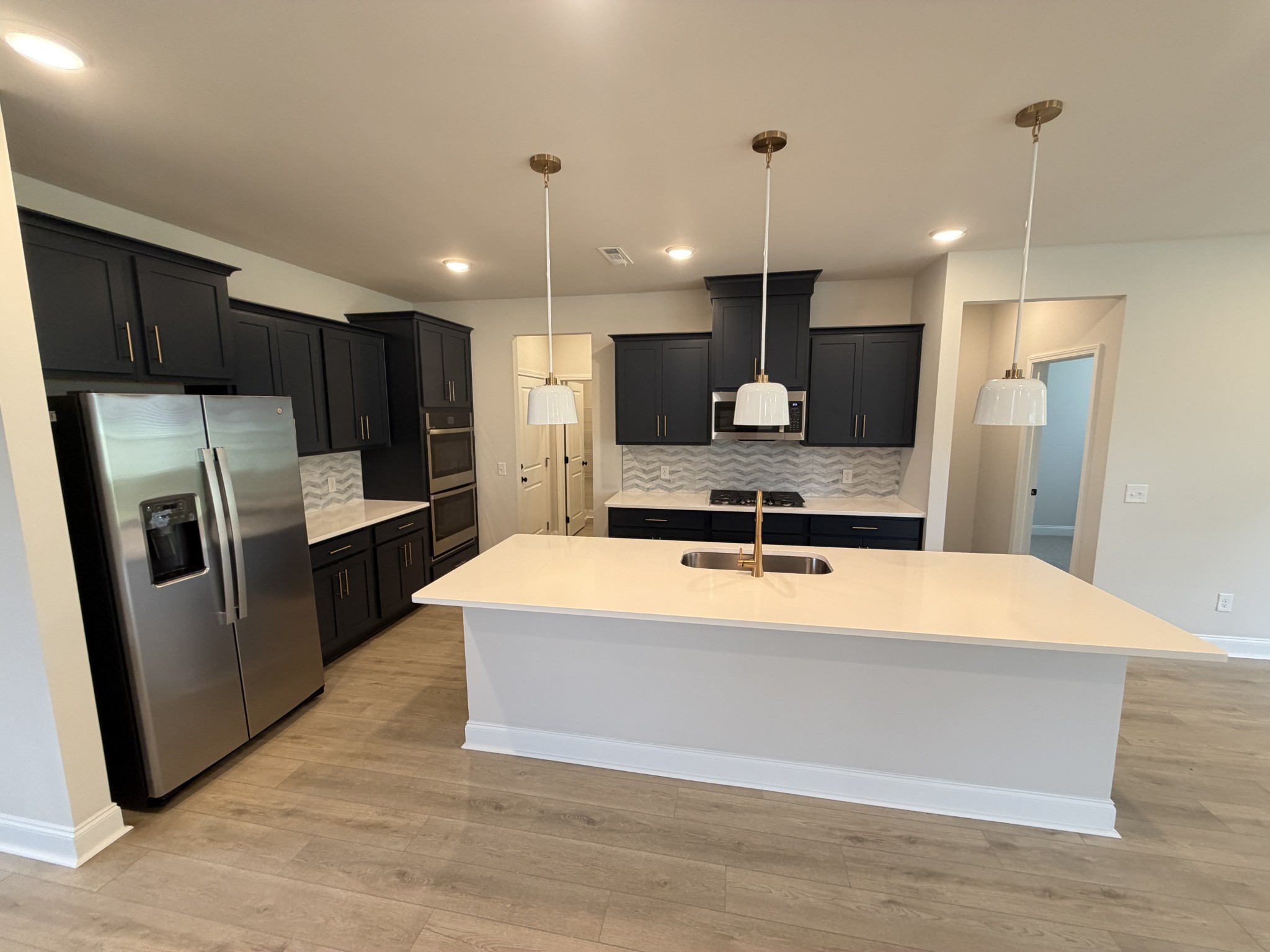 147 Emeline Way Mount Juliet, TN 37122 - Photo 8 of 41 a large kitchen with kitchen island a large counter top stainless steel appliances and cabinets