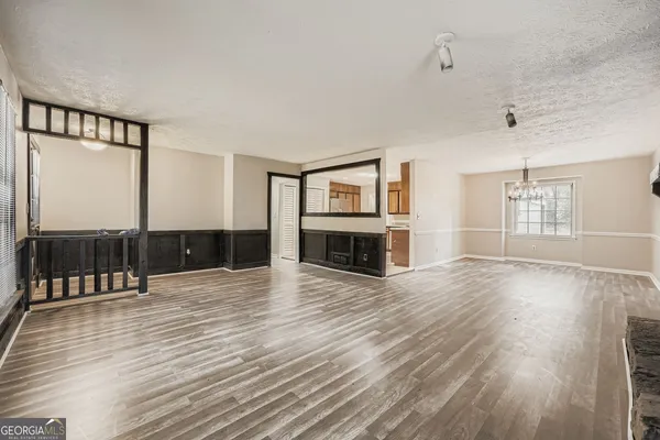 an empty room with wooden floor and fireplace