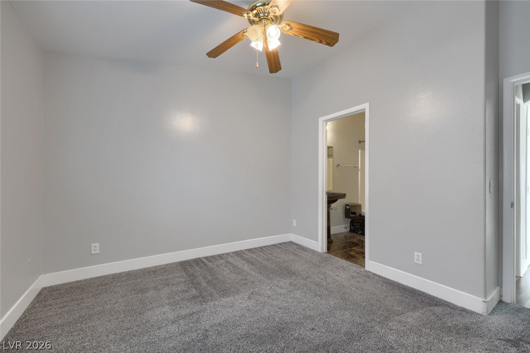 5985 High Steed Street, Unit 101 Henderson, NV 89011 - Photo 22 of 38 A spacious bedroom features plush carpet and an en-suite bathroom access.