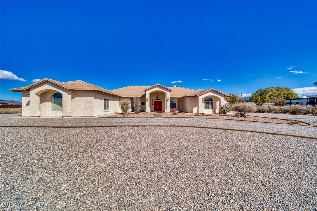 660 Indian Road Pahrump, NV 89048 - Photo 1 of 54 Featuring multiple decorative mediterranian-style arches, concrete-tile roof, decorative concrete curbing, & over 385 tons of 3/4 inch multi-color stone. Note: 3-car garage on west-side of home (left-side of image).
