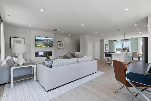 a living room with furniture and a dining table with wooden floor
