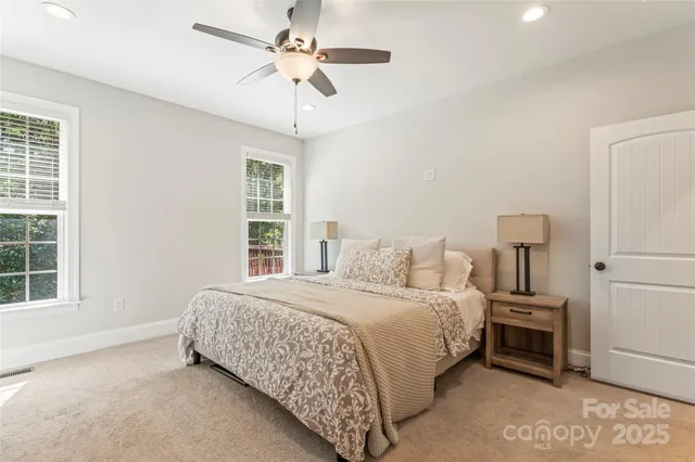 a bedroom with a bed next to a window and a chandelier