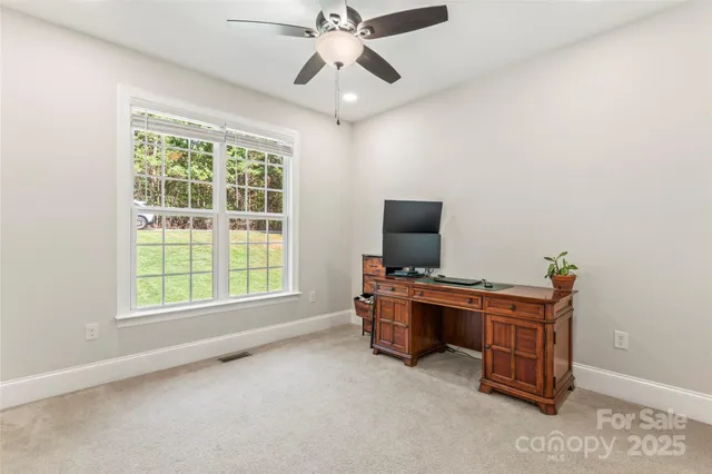 a view of a workspace with furniture and a window