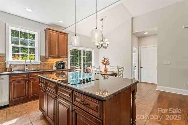 a kitchen with kitchen island granite countertop a sink window and cabinets