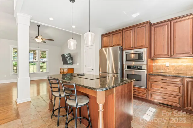 a kitchen with stainless steel appliances kitchen island granite countertop a refrigerator and microwave