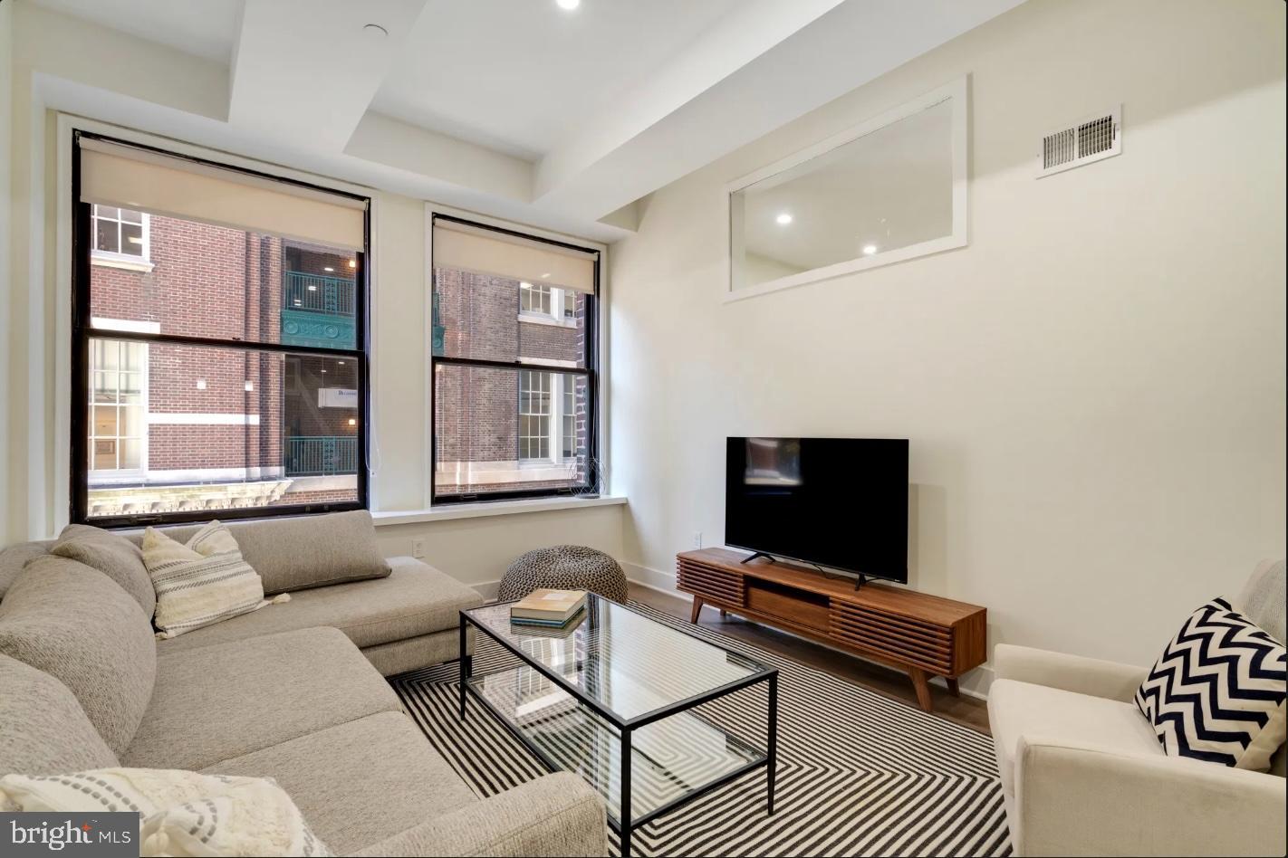 150 South Independence Mall West, Unit 1013 Philadelphia, PA 19106 - Photo 10 of 16 a living room with furniture a flat screen tv and a window