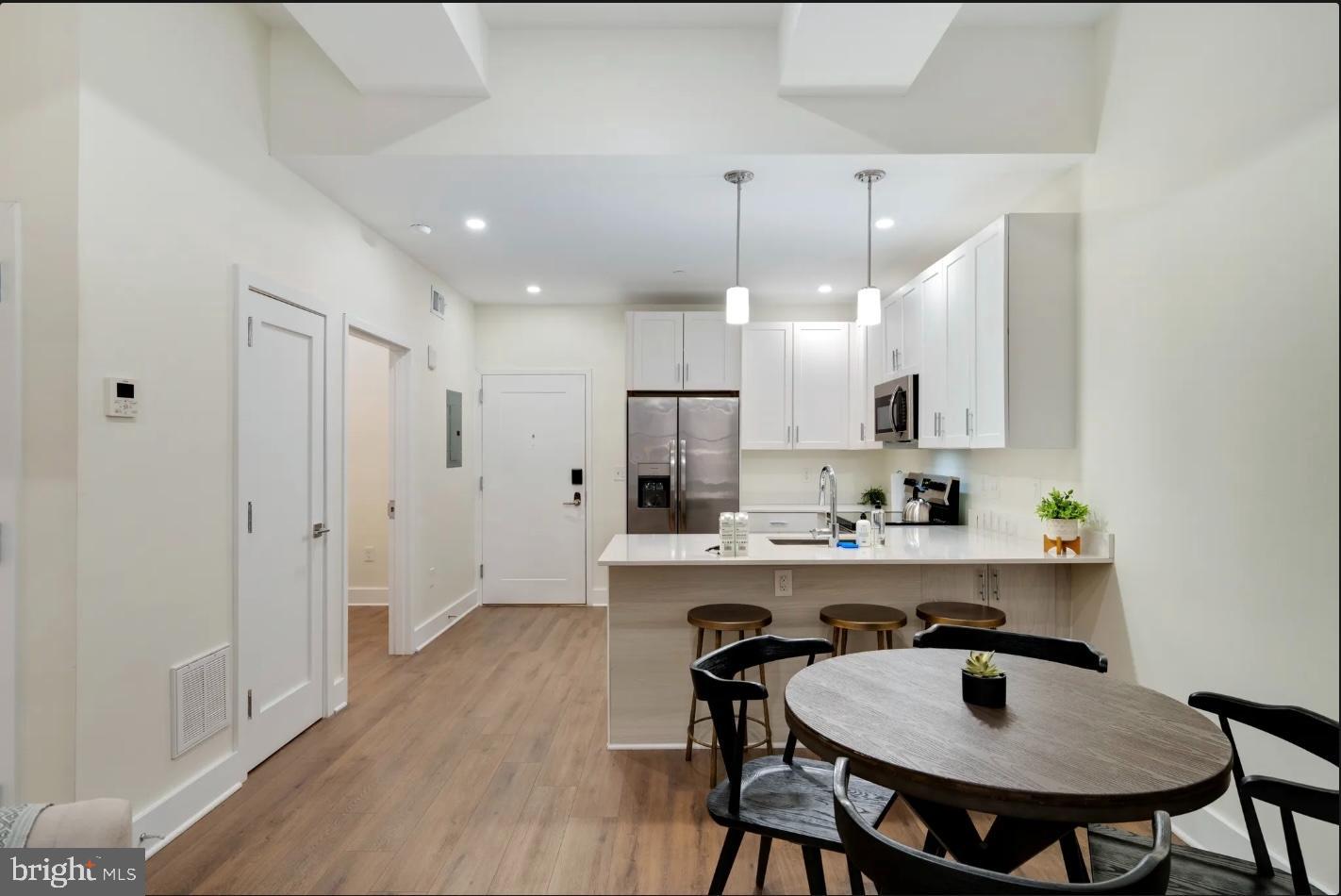 150 South Independence Mall West, Unit 1013 Philadelphia, PA 19106 - Photo 11 of 16 a kitchen with kitchen island a dining table chairs sink and cabinets