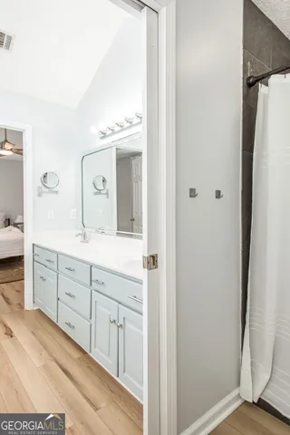 a white toilet sitting next to a white sink and vanity