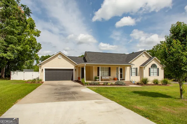 a front view of a house with a yard and trees