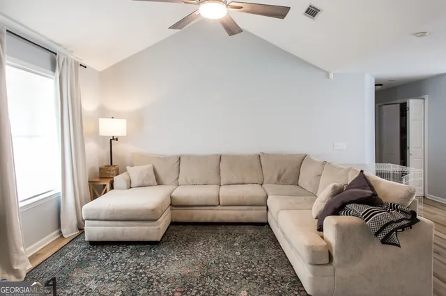 a living room with furniture and a lamp