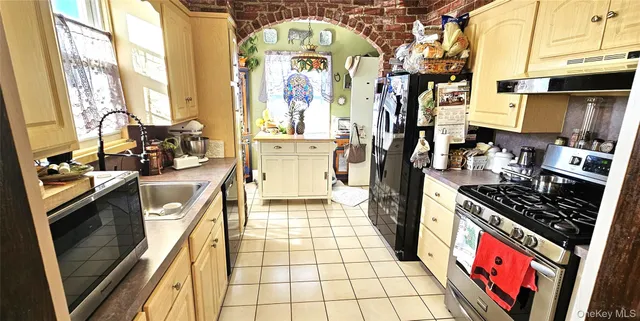 a kitchen with stainless steel appliances granite countertop a stove a sink and a refrigerator