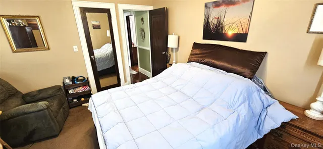 a bed sitting in a bedroom next to a window with pc on the wall